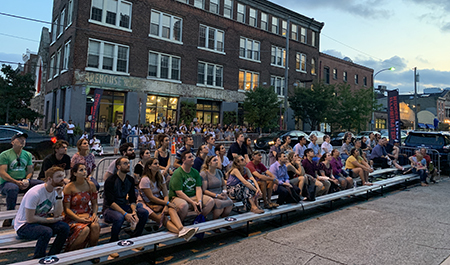 Visitors watching the films on bleachers outside along Fairmount Avenue