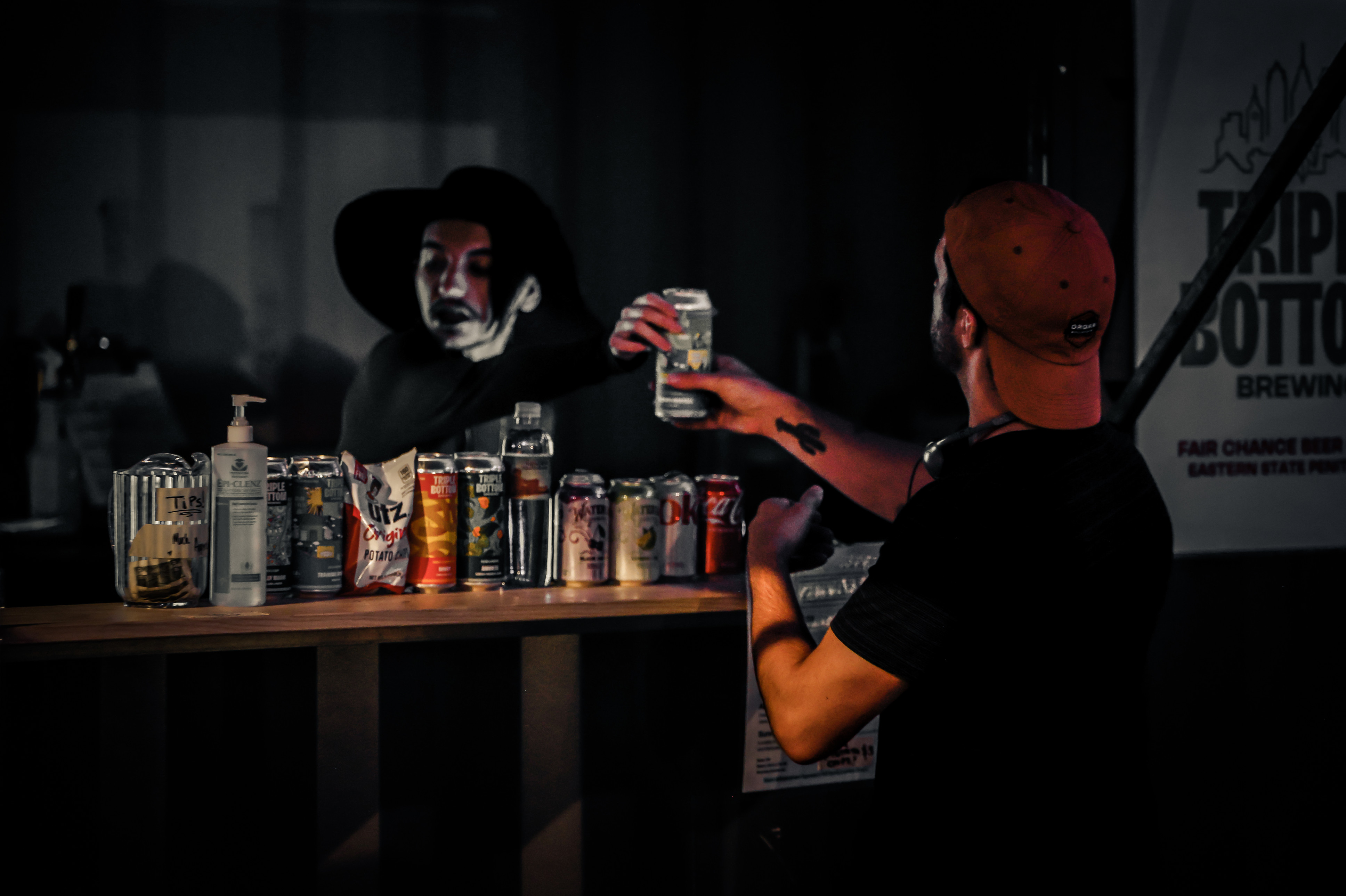 A photo of a bartender handing a drink to a guest in the Fair Chance Beer Garden