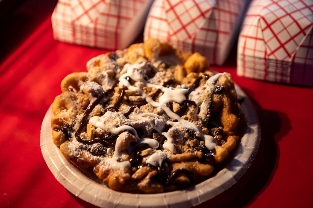 A photo of a funnel cake with colorful toppings