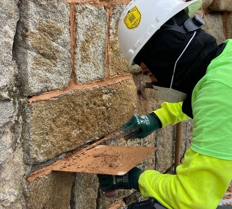 A modern day photo of a preservation trades center participant doing masonry work at Eastern State Penitentiary.