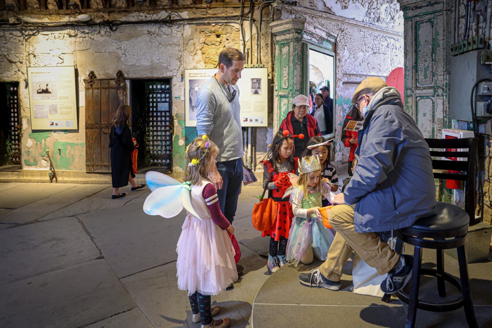 A photo of young visitors in costumes receiving candy from a tour guide during Eastern State's Fall Festival.