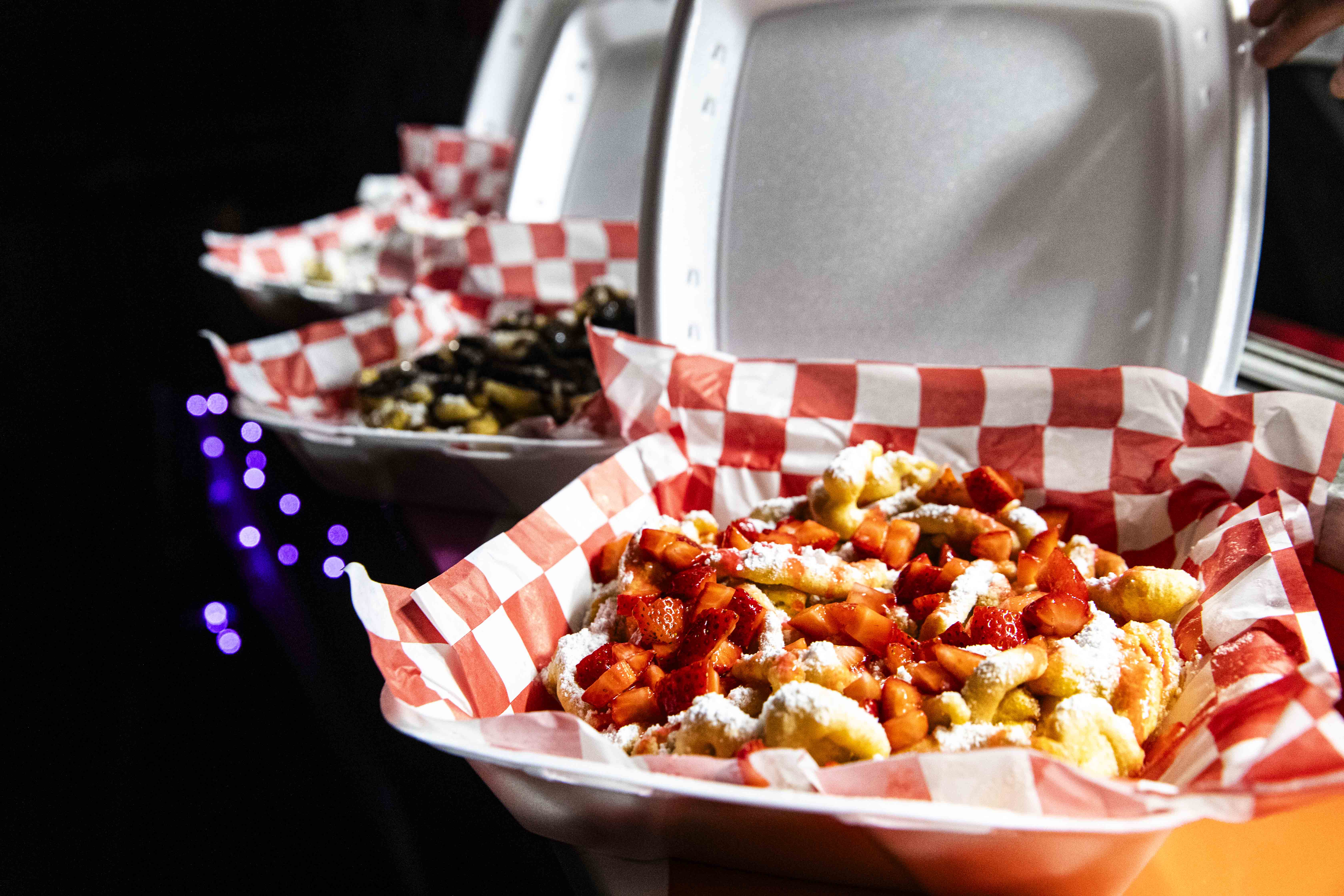 A photo of a funnel cake with colorful toppings